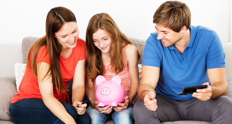 couple with child holding a piggy bank