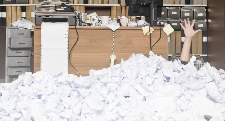 hand emerging from piles of wadded up paper