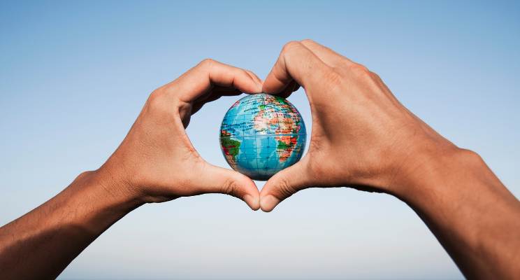 hands in heart shape with globe